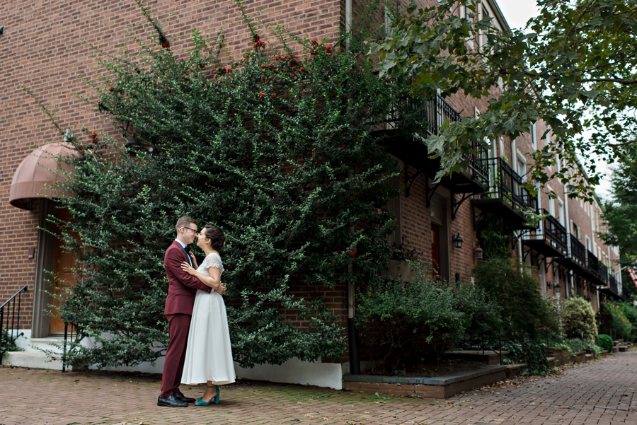 A bride and groom kiss on the corner of a Philadelphia street on the way to the ceremony.